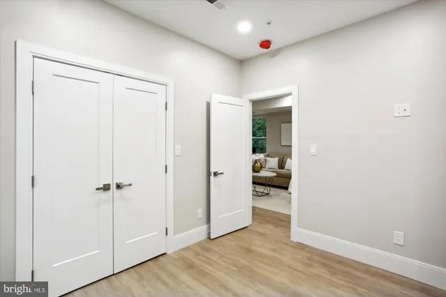 a view of a hallway with wooden floor and closet