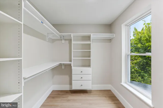 a view of walk in closet with empty racks
