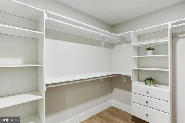 a view of walk in closet with clothes and shoes