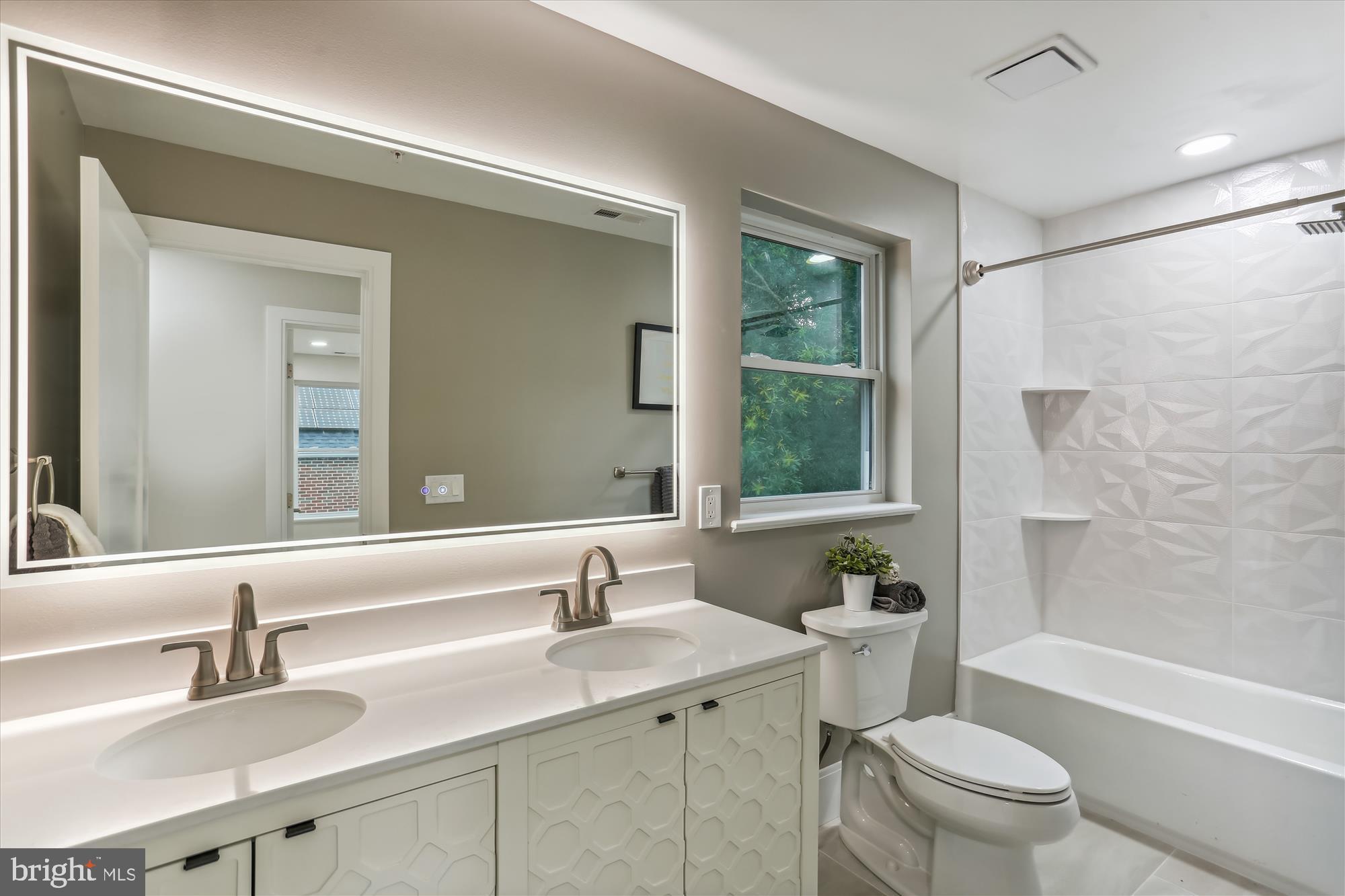 620 Mississippi Avenue Silver Spring, MD 20910 - Photo 37 of 50 a bathroom with a toilet a sink a mirror a bathtub and shower