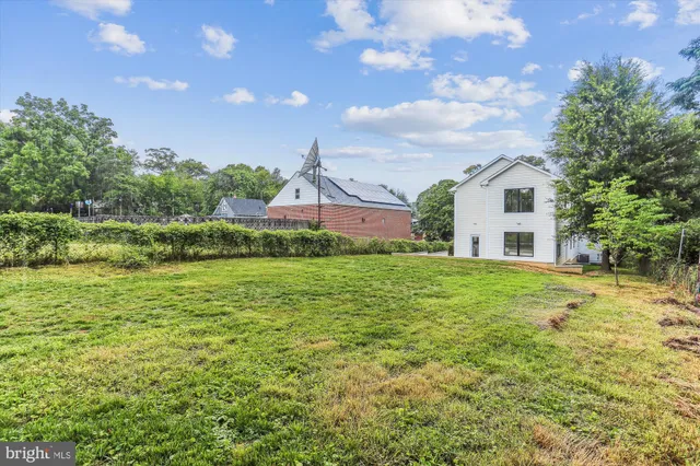 a front view of house with yard and trees in the background
