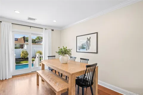 a view of a dining room with furniture a potted plant and wooden floor
