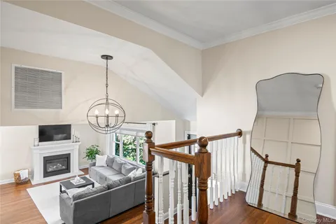 a view of a hallway with wooden floor and stairs