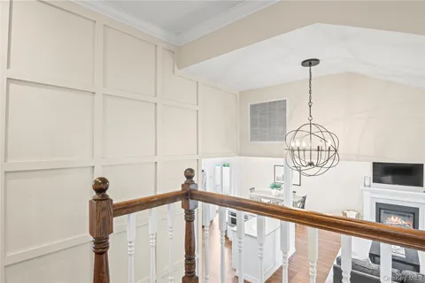 a living room with furniture a fireplace and a chandelier