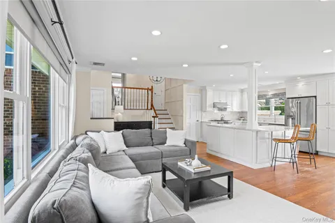 a living room with furniture and a dining table with kitchen view