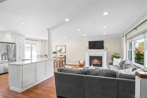 a living room with furniture and a dining table with kitchen view