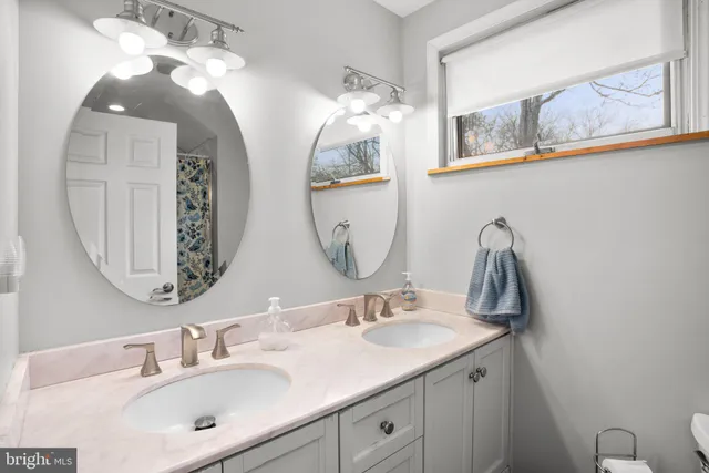 a bathroom with a double vanity sink and a mirror