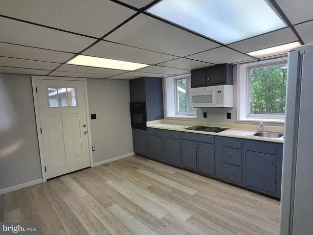 a kitchen with stainless steel appliances granite countertop a sink window and cabinets