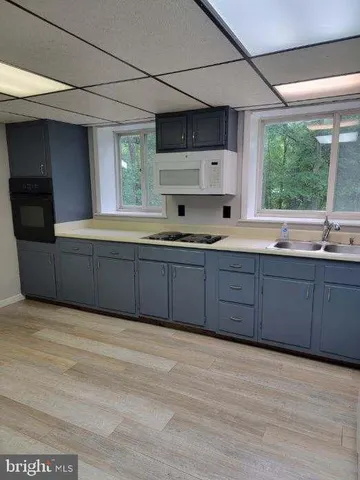 a kitchen with stainless steel appliances granite countertop a refrigerator a sink dishwasher a stove and a microwave oven