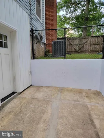 a view of backyard with large trees and wooden fence