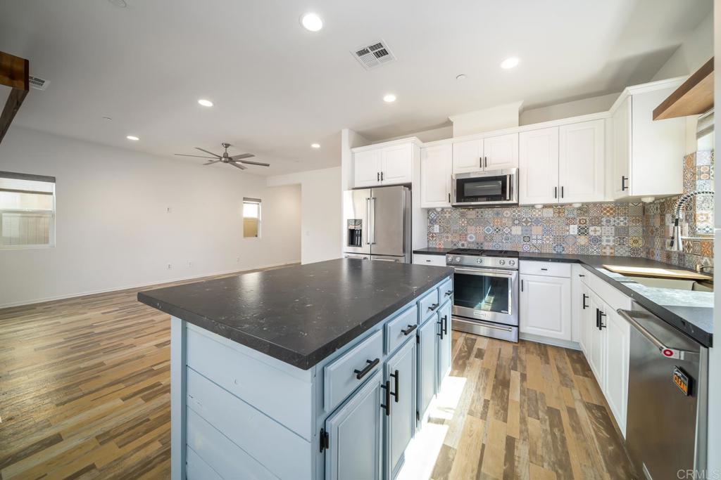 313 Dun Blazer Way Fallbrook, CA 92028 - Photo 13 of 59 a kitchen with stainless steel appliances granite countertop a sink stove and refrigerator