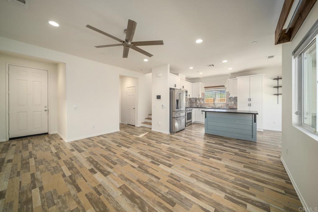 313 Dun Blazer Way Fallbrook, CA 92028 - Photo 6 of 59 a view of kitchen and empty room with wooden floor