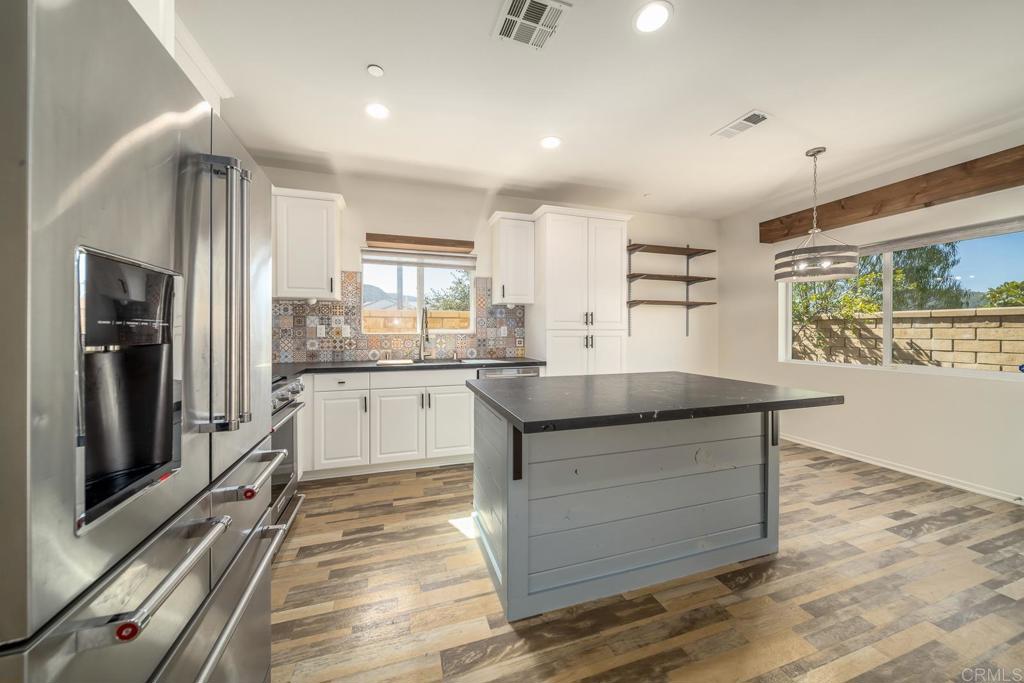 313 Dun Blazer Way Fallbrook, CA 92028 - Photo 10 of 59 a kitchen with granite countertop white cabinets and refrigerator