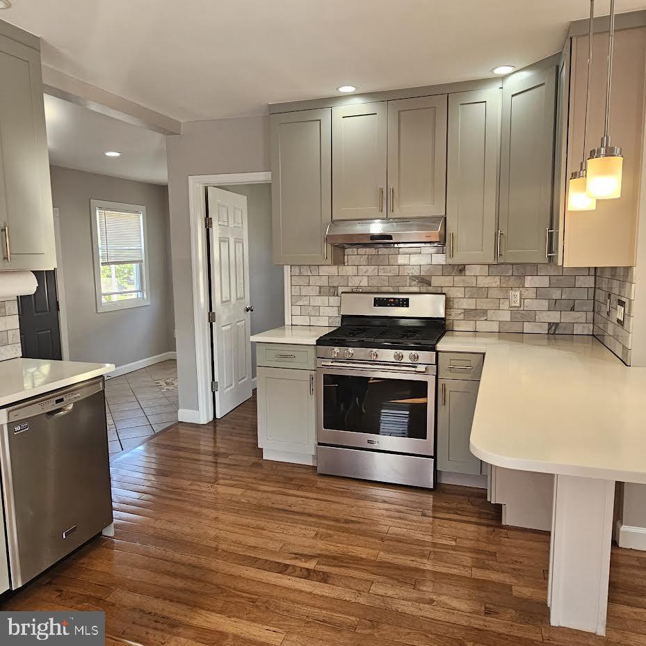 23 Long Avenue, Unit 2 Hillside, NJ 07205 - Photo 3 of 13 a kitchen with stainless steel appliances a stove a sink cabinets and wooden floor