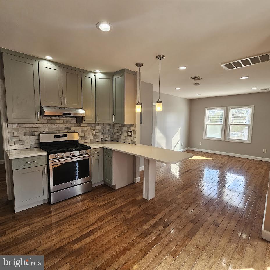 23 Long Avenue, Unit 2 Hillside, NJ 07205 - Photo 6 of 13 a kitchen with stainless steel appliances kitchen island granite countertop a stove a sink and a wooden floors