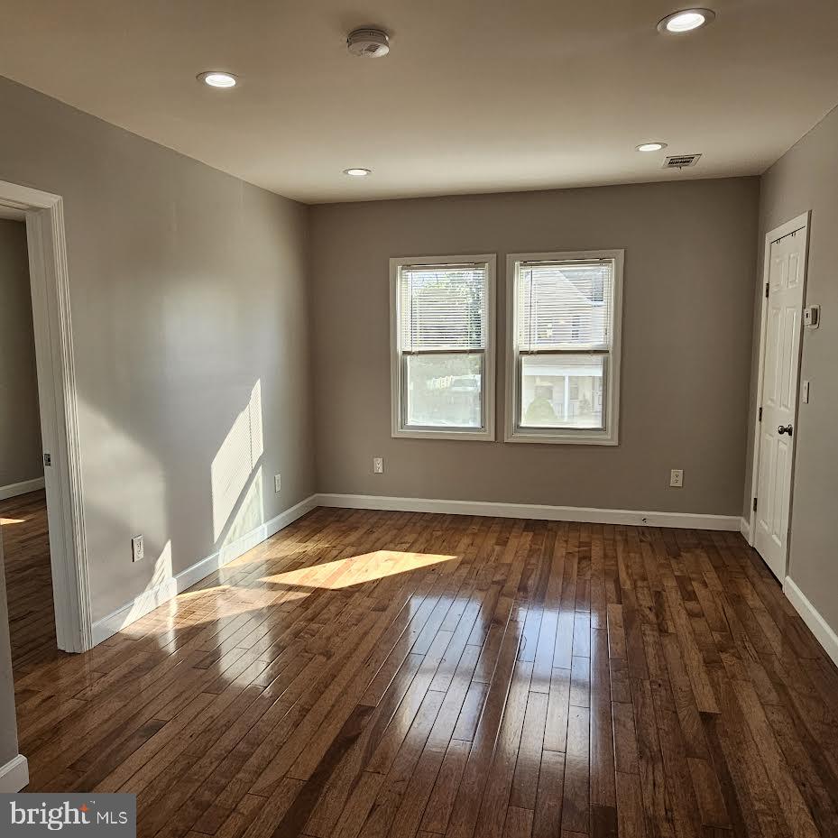 23 Long Avenue, Unit 2 Hillside, NJ 07205 - Photo 7 of 13 an empty room with wooden floor and windows