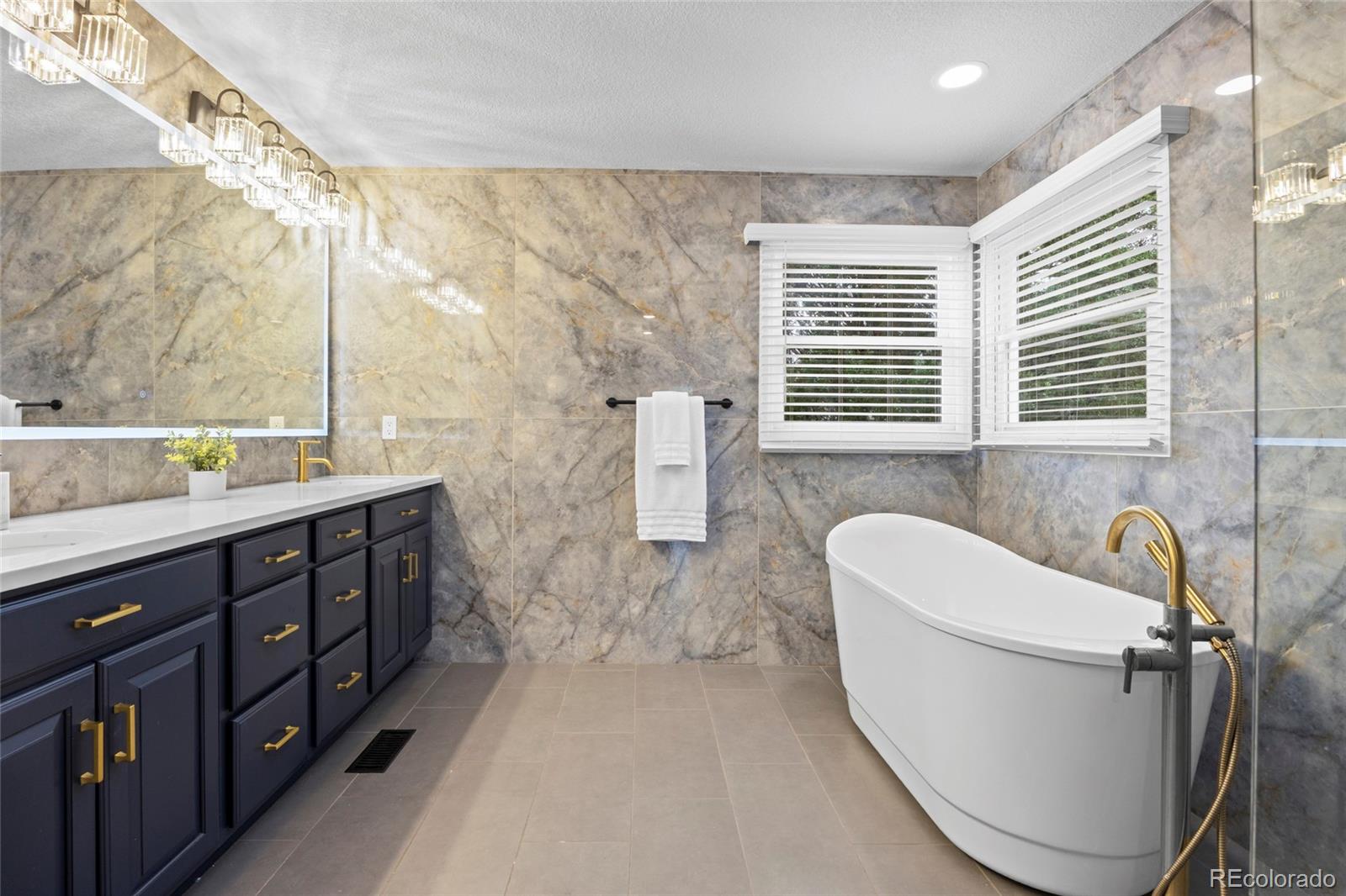 7 Red Maple Place Littleton, CO 80127 - Photo 22 of 50 a bathroom with a double vanity sink a toilet a window and tub