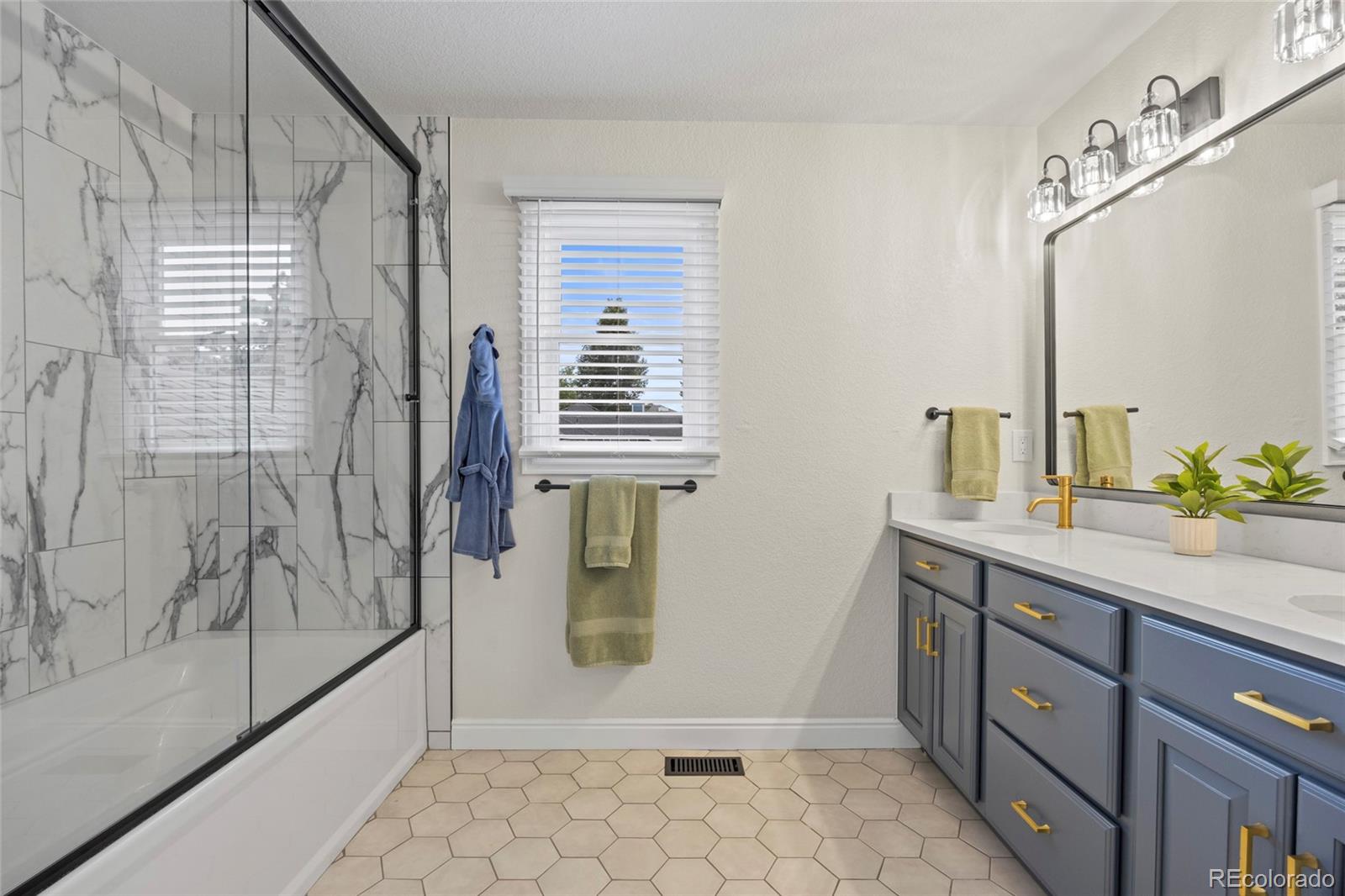 7 Red Maple Place Littleton, CO 80127 - Photo 26 of 50 a bathroom with a granite countertop sink a mirror and shower