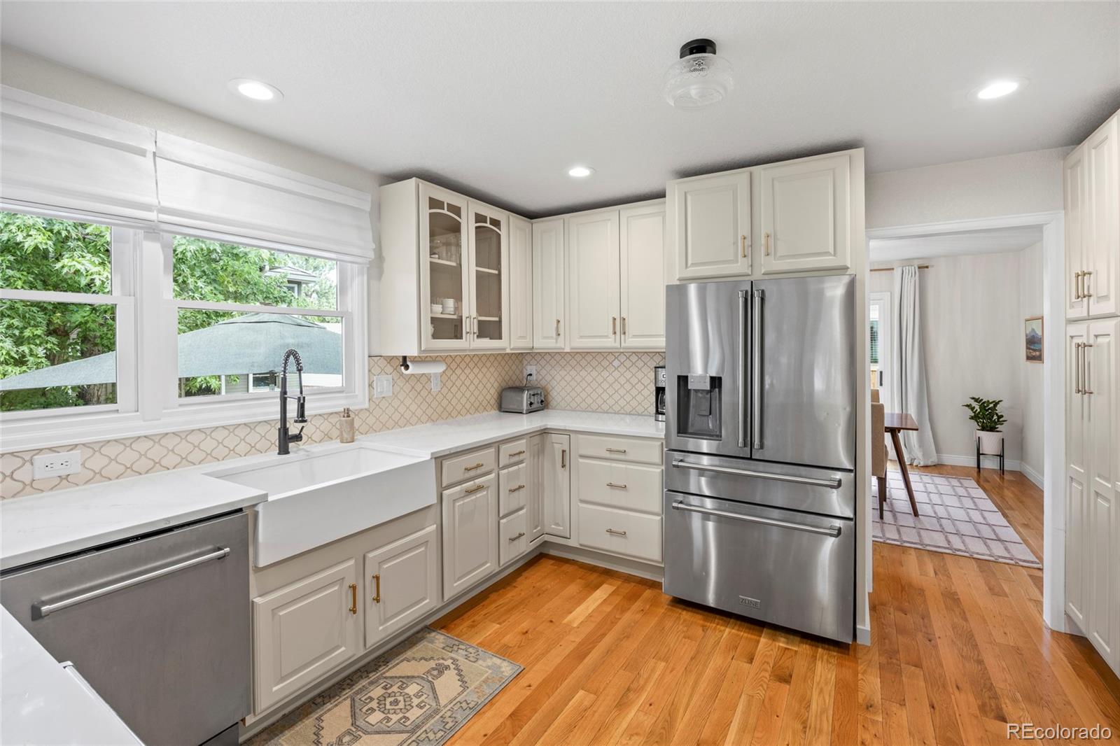 7 Red Maple Place Littleton, CO 80127 - Photo 7 of 50 a kitchen with stainless steel appliances a refrigerator sink and wooden floor