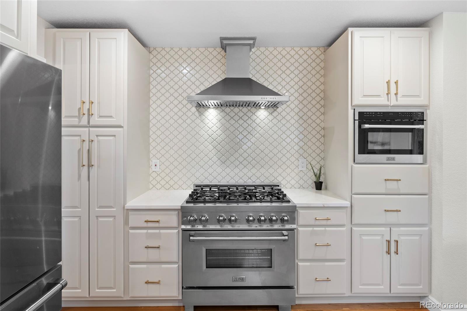 7 Red Maple Place Littleton, CO 80127 - Photo 9 of 50 a kitchen with white cabinets and appliances