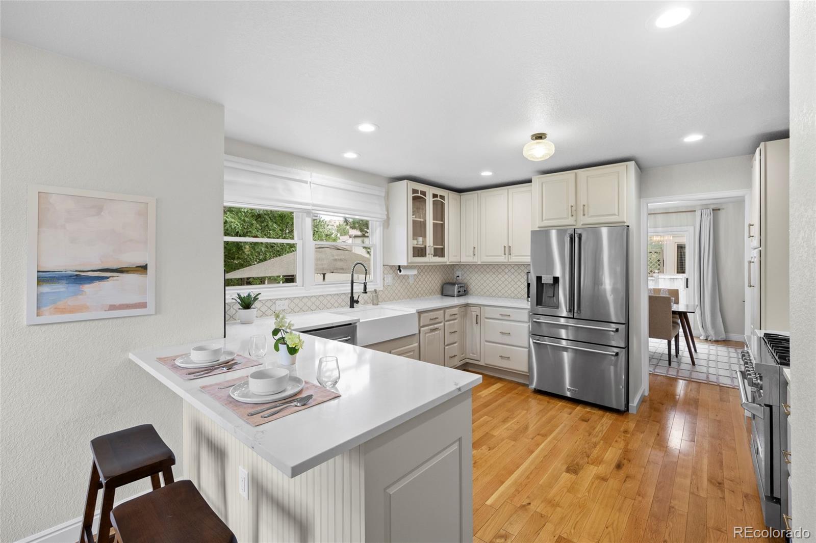 7 Red Maple Place Littleton, CO 80127 - Photo 10 of 50 a kitchen with stainless steel appliances a dining table and chairs