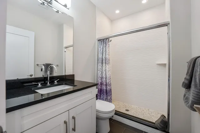 a bathroom with a granite countertop sink toilet and shower