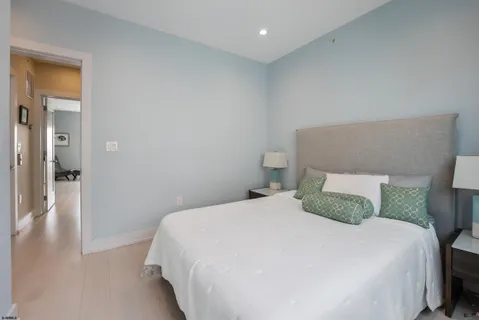 a bedroom with a bed and hardwood floor