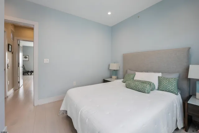 a bedroom with a bed and hardwood floor