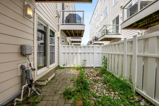 a view of a house with a small yard and wooden floor and fence