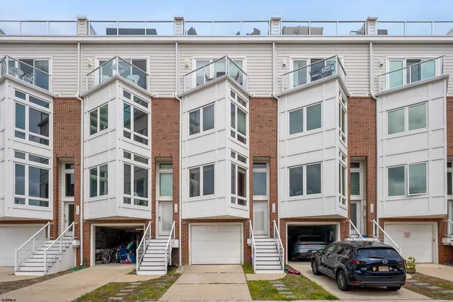 a view of a house with a barbeque and wooden fence