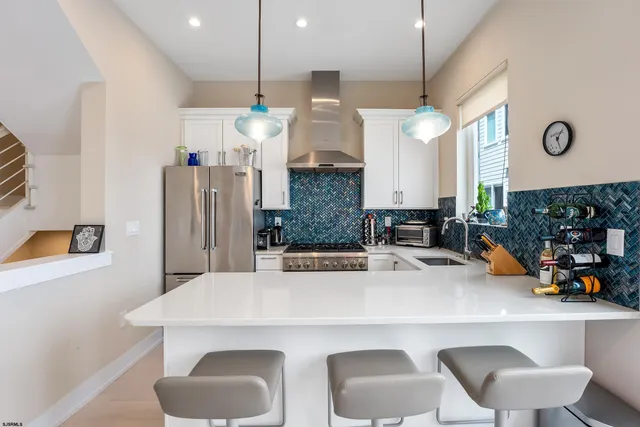 a kitchen with stainless steel appliances a table chairs and a refrigerator