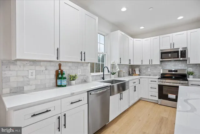 a kitchen with stainless steel appliances granite countertop a sink a stove and cabinets