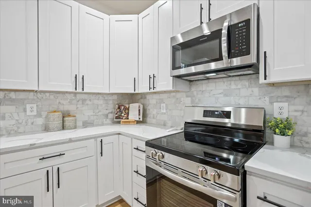 a kitchen with stainless steel appliances a stove a microwave a sink and cabinets