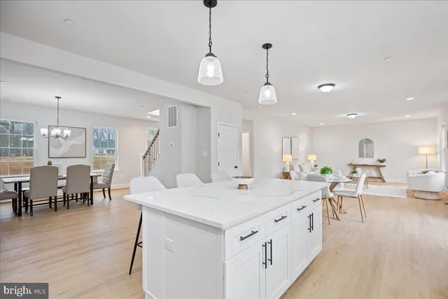 a large white kitchen with a dining table chairs and couches