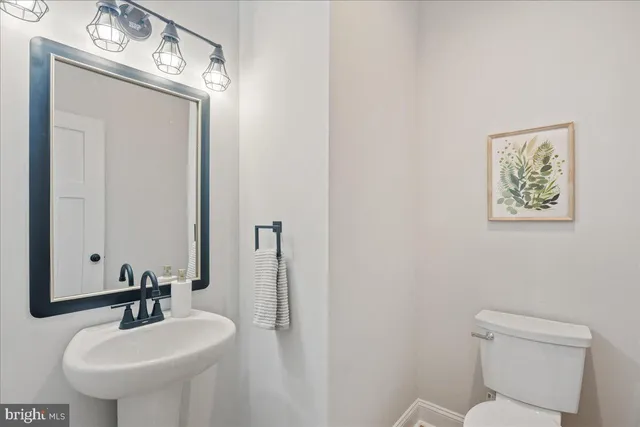a bathroom with a toilet a sink and mirror