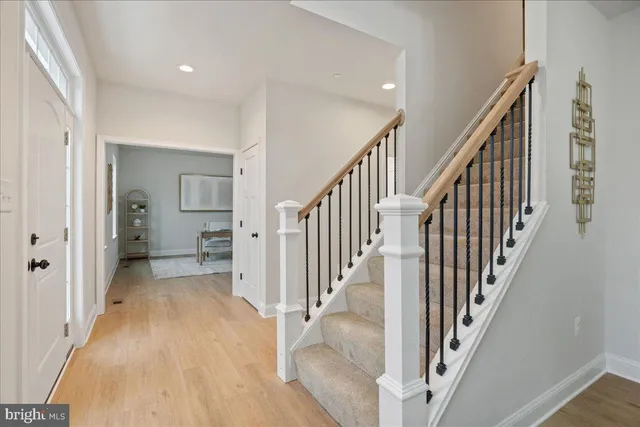 a view of a hallway with wooden floor and stairs
