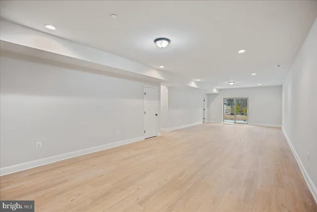 an empty room with wooden cabinet and windows