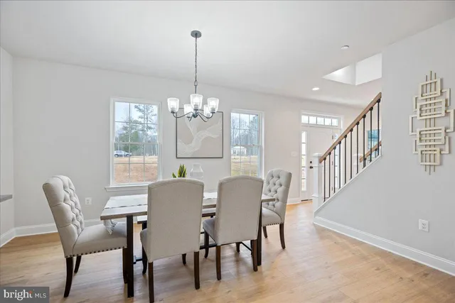 a view of a dining room with furniture a chandelier and wooden floor