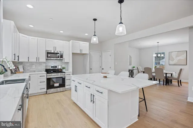 a large white kitchen with lots of counter space sink and appliances