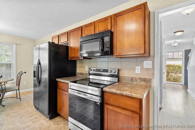 a kitchen with stainless steel appliances granite countertop a refrigerator stove and sink