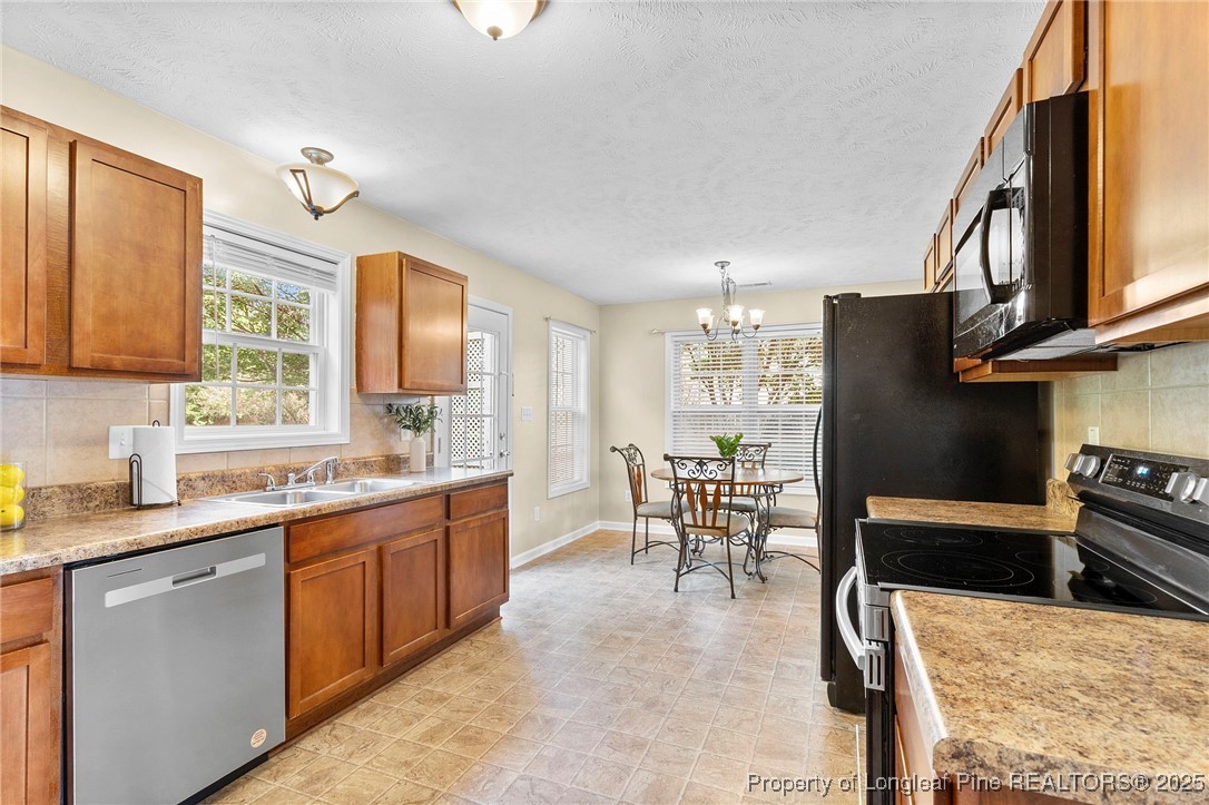 198 Cape Fear Road Raeford, NC 28376 - Photo 13 of 32 a kitchen with stainless steel appliances granite countertop sink stove refrigerator dining table and chairs