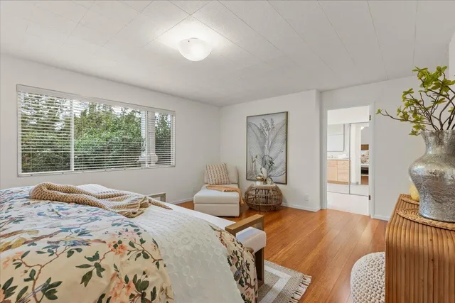 a bedroom with a bed and wooden floor