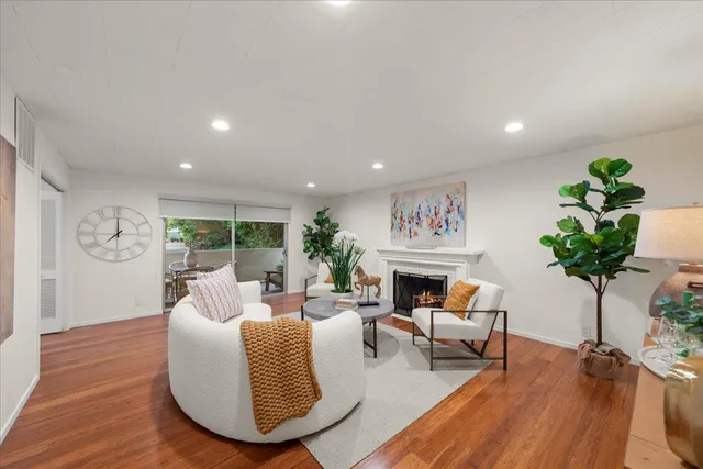 a living room with furniture fireplace and wooden floor