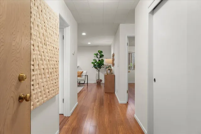 a view of a hallway with wooden floor and staircase