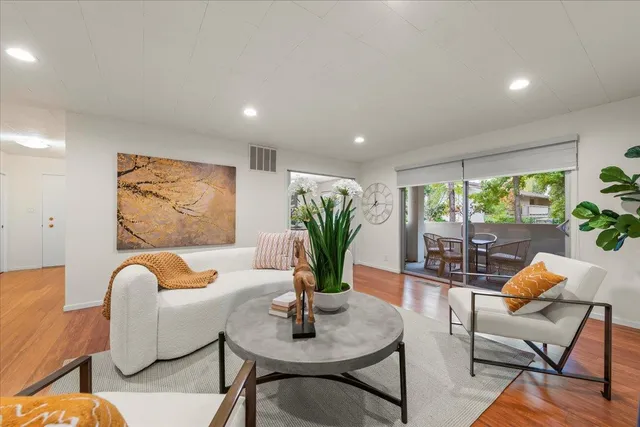 a living room with furniture plant and a window