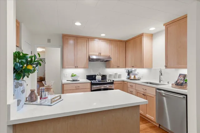 a kitchen with kitchen island sink stove and cabinets