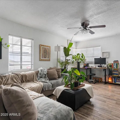 a living room with furniture and a wooden floor