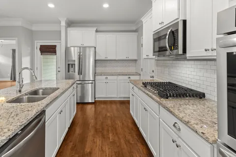 a kitchen with a sink stove microwave and refrigerator