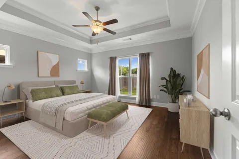 a bedroom with a large bed wooden floor and a large window