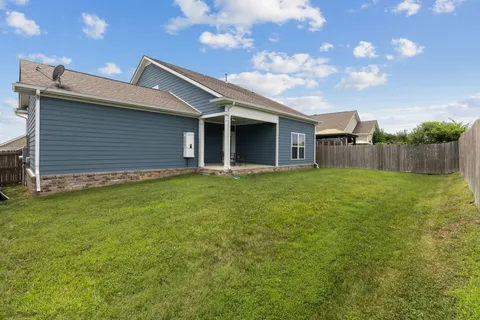 a backyard of a house with table and chairs